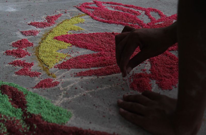 The creation of the Rangoli often begins with sketching of the outline with chalk and the filling in the coloured materials (Vishani Ragobeer photo)