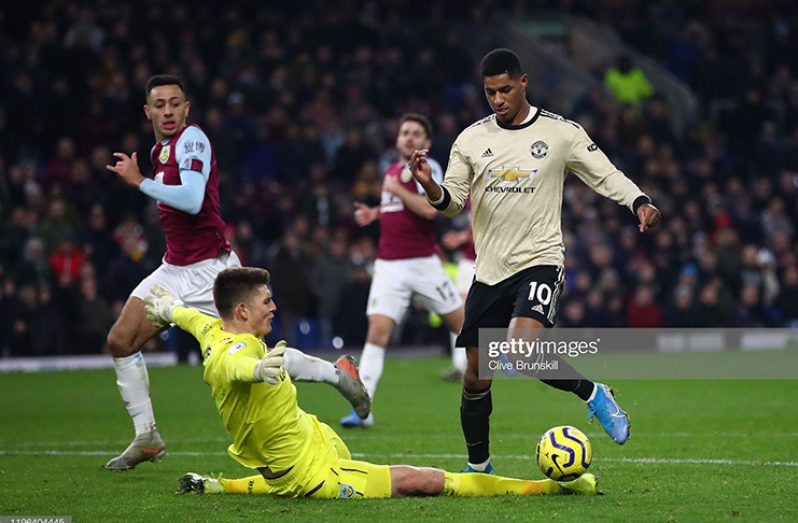 Marcus Rashord of Manchester United goes round Nick Pope of Burnley FC to score his teams second goal during the Premier League match between Burnley FC and Manchester United at Turf Moor on December 28, 2019 in Burnley, United Kingdom. (Photo by Clive Brunskill/Getty Images)
