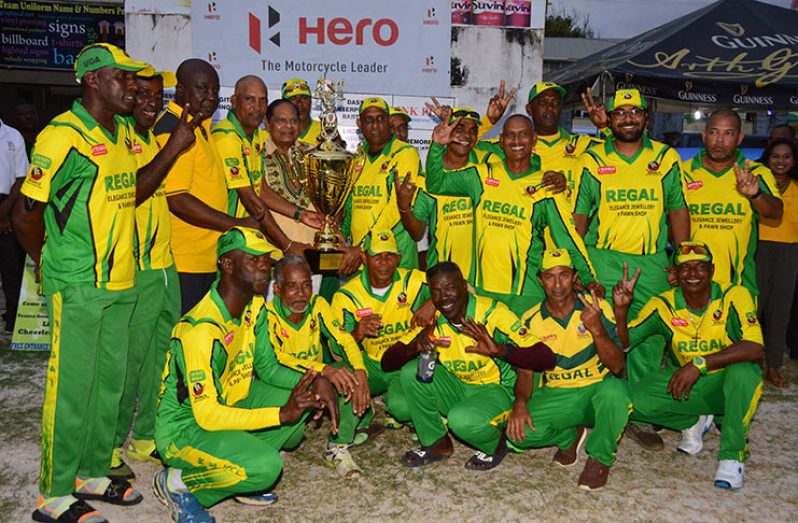 FLASHBACK: Prime Minister Moses Nagamootoo hands over the winning Masters Over-45 trophy to Regal Masters skipper Mahendra Arjune as the jubilant players celebrate last year’s win.