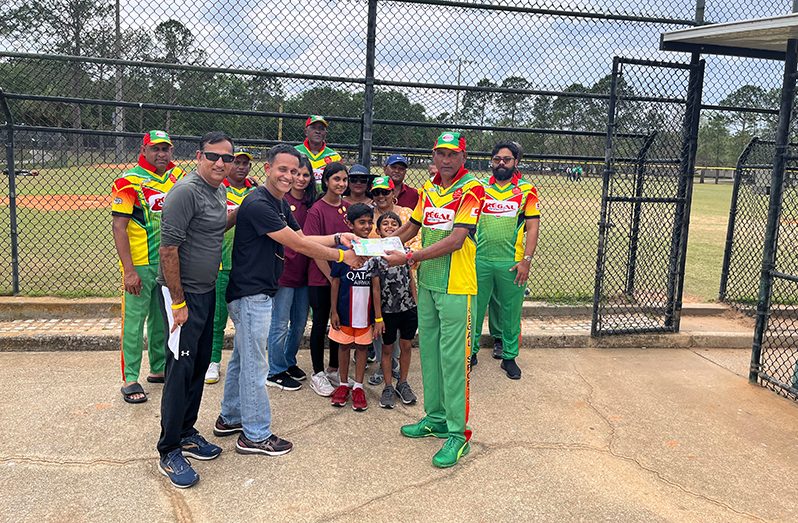 Mahendra “Anil” Hardyal (right) hands over donation to volunteer, Pavan Dudella, in the presence of some members of Regal Legends and from the group, Who We Play For.