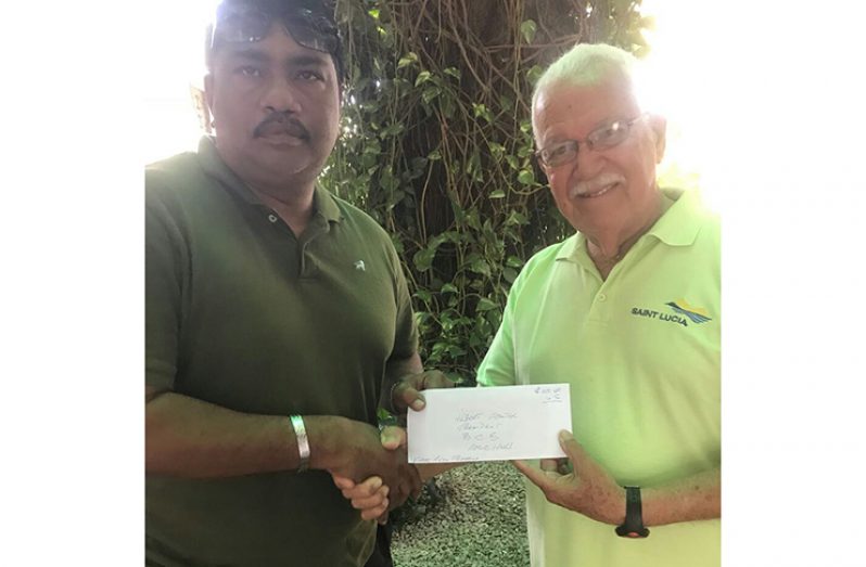 Anil Beharry receives the donation from Joseph ‘Reds’ Perreira.