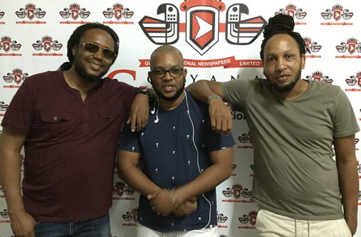 Reggae artistes Duane Stephenson and Mackeehan Solomon alongside Denvo 'DJ Denvo' Thombs [centre] during a visit to the Guyana Chronicle