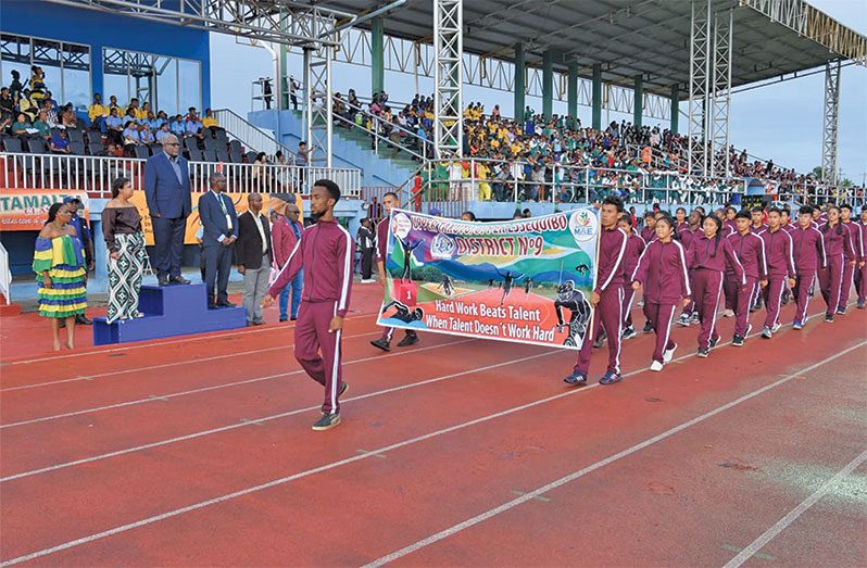 District 9 athletes march past the officials headed by Prime Minister (ret’d) Brigadier Mark Phillips and Minister of Education, Priya Manickchand. (DPI photos)