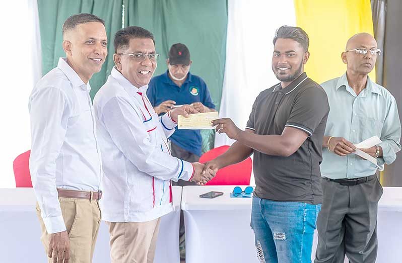 Minister of Agriculture Zulfikar Mustapha and Minister within the Ministry of Agriculture, Vikash Ramkissoon handing over a cheque to a farmer (Delano Williams photos)