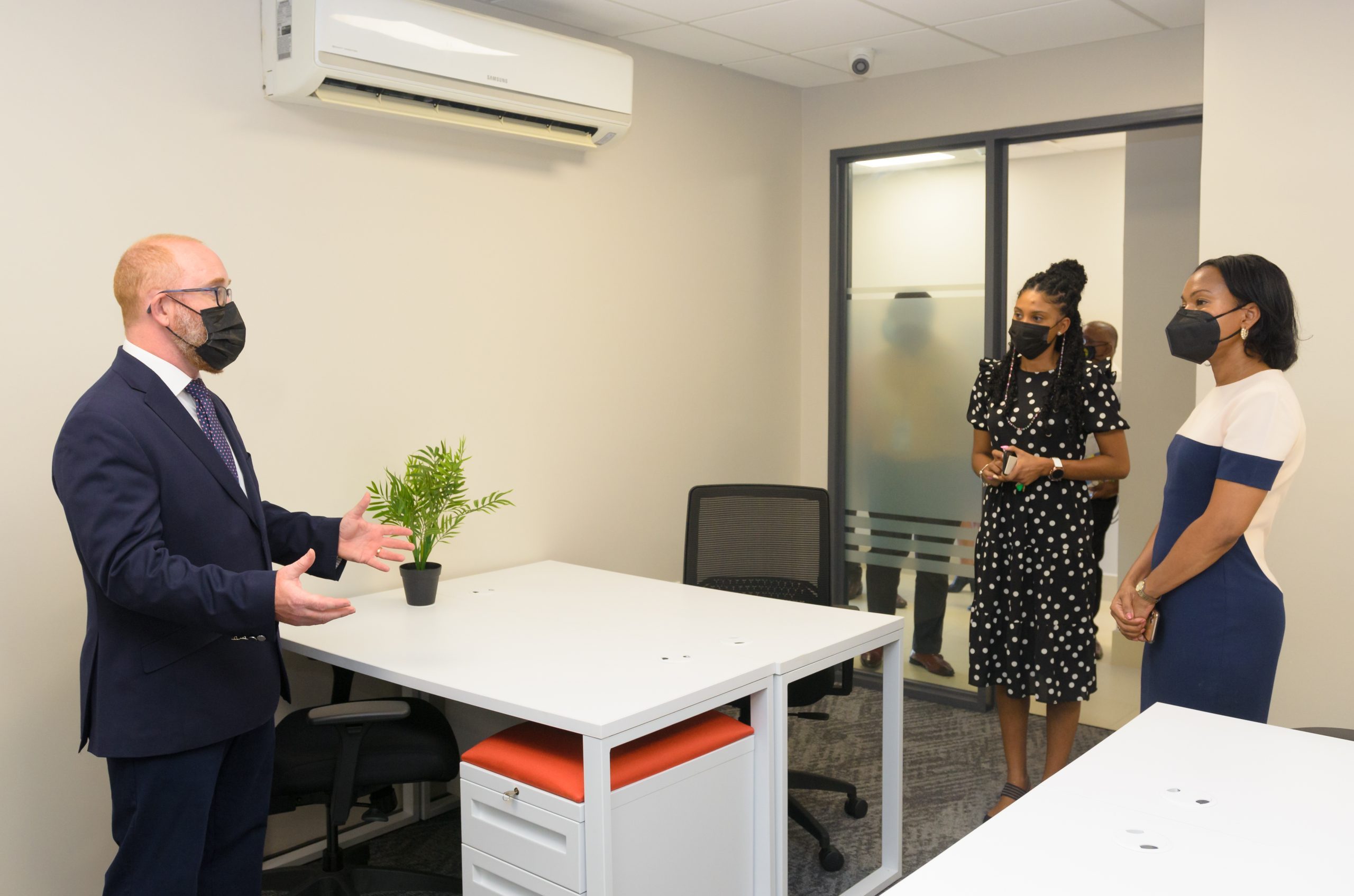 Stuart May, Regus Operations Caribbean Director giving Minister of Tourism, Industry and Commerce, Oneidge Walrond (right) a tour of the facility on Monday