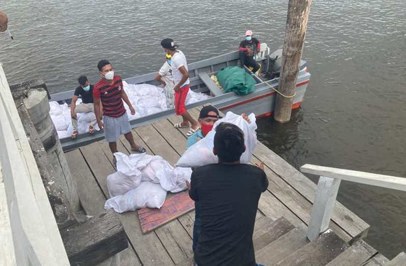 Residents offload the relief hampers for distribution