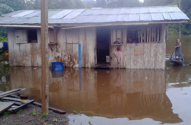 Floodwaters near a home at Chenapau, Region Eight