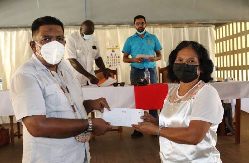 Minister of Agriculture Zulfikar Mustapha handing over one of the cash grants to a Kabakaburi resident on Saturday