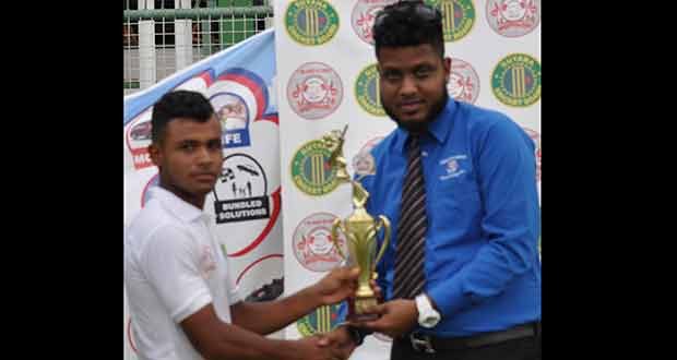 Hand-in-Hand Insurance Company representative, Mikhail DaSilva hands over the Man-of-the-Match trophy to Ronaldo Renee.