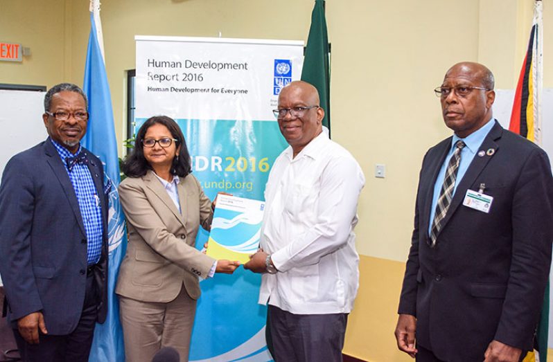The 2016 Human Development Report being presented to Finance Minister, Winston Jordan, by UNDP Deputy Resident Representative, Shabnam Mallick. Also in photo are UG Vice-Chancellor, Dr. Ivelaw Griffith and Finance Secretary, Dr. Hector Butts