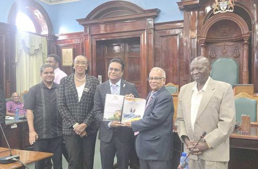 Auditor General Deodat Sharma hands over the report to Speaker of the National Assembly, Manzoor Nadir in the presence of staff of the Audit Office and Finance Secretary Sukrishnalall Pasha
