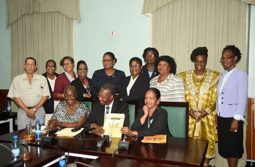 Commissioners of the Women and Gender Commission along with Dr. Barton Scotland (seated centre) and Indra Chanderpaul (seated right)