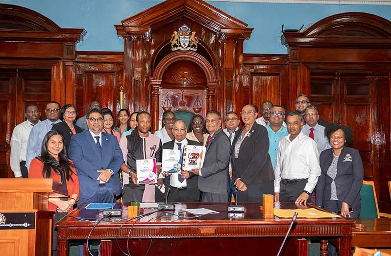 Auditor-General Deodat Sharma and Speaker of the National Assembly Manzoor Nadir pose for a photo with the reports that were handed over. Also pictured are Members of the Parliamentary Public Accounts Committee, staff of the Audit Office and the Ministry of Finance (Delano Williams photos)