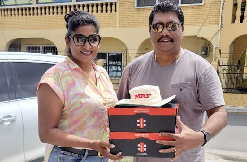 Reshma Mathura (left) presents the tokens to Anil Beharry.