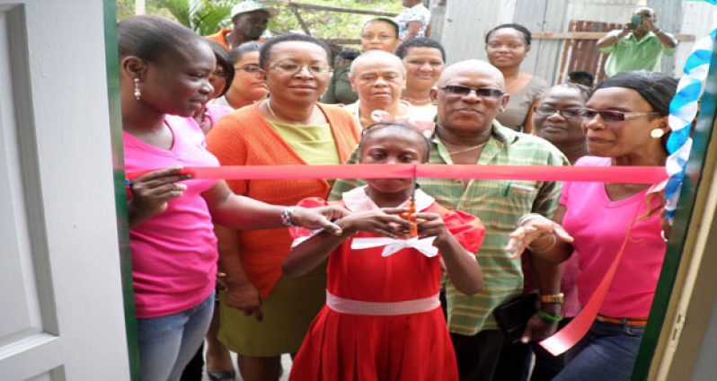 The symbolic cutting of the ribbon by a student of the Special Needs School.