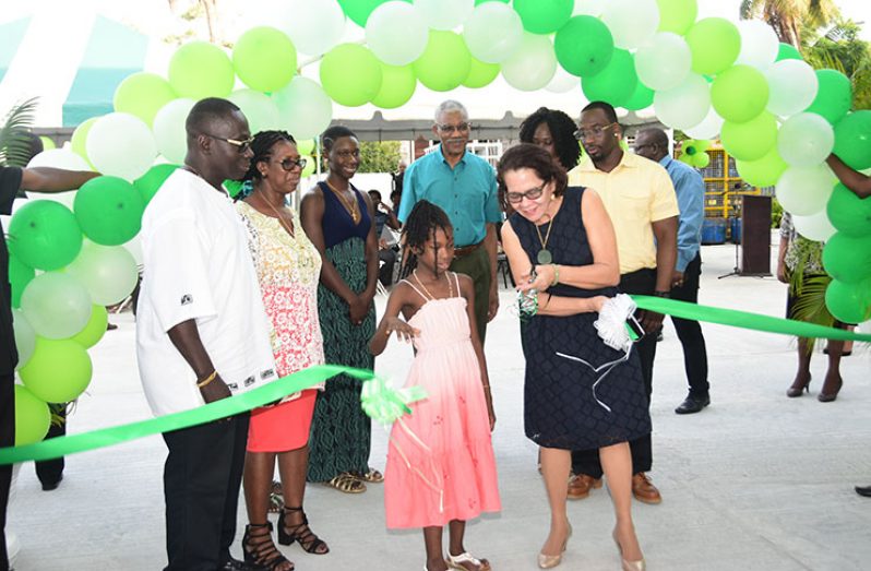 First Lady Sandra Granger and the youngest grandchild of proprietor Morris Wilson cut the ribbon to mark the official opening of the Buxton-Friendship Guyoil gas station. Also in photo are Morris Wilson (left), Mrs. Wilson (second left), President David Granger (centre) and children of the proprietors