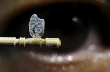 Miniature artist Chen Forng-Shean poses with his latest work, a miniature portrait of Taiwanese president-elect Tsai Ing-wen on a grain of rice, in Taipei, Taiwan April 18, 2016. The Chinese characters read, "Modest, modest and even more modest." (REUTERS/Tyrone Siu)