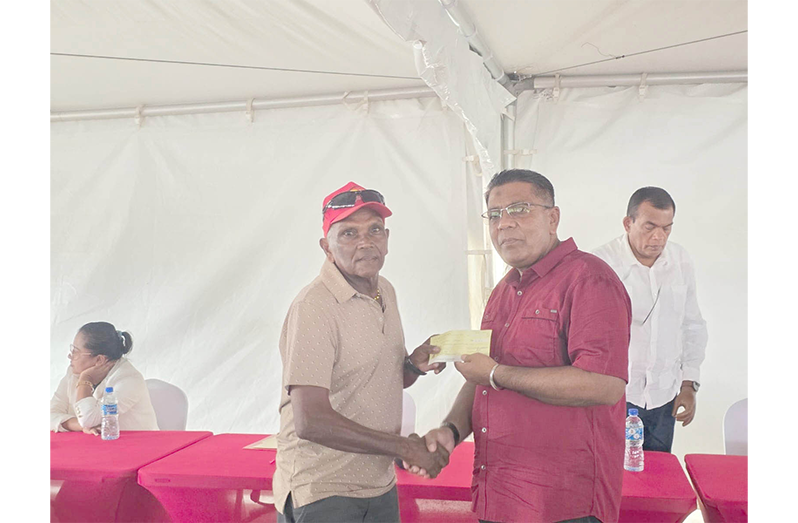Minister of Agriculture Zulfikar Mustapha handing over a cheque to a rice farmer
