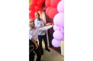 With scissors in hand, President & CEO of Financial Acumen, Inc, Richard Outram, flanked by other officials, formally cut the ribbon to commission the Literacy Centre