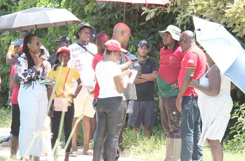Minister of Public Works, Bishop Juan Edghill and prominent Attorney and businessman, James Bond, speak to a contractor about ongoing road, drainage and irrigation works
