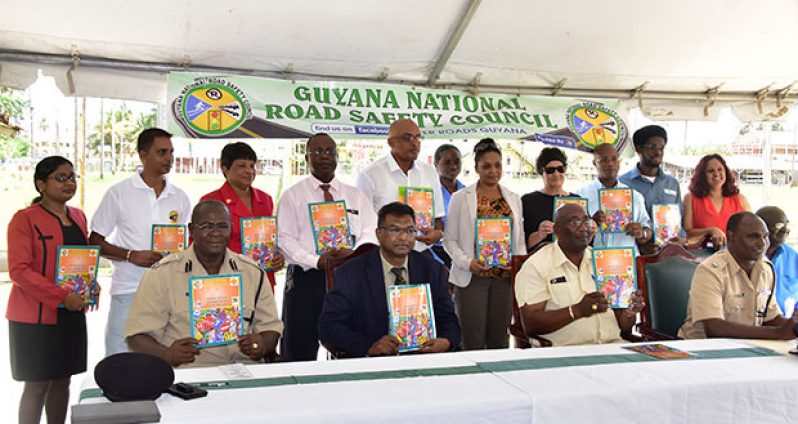 Minister of Public Security Khemraj Ramjattan ( seated second from left) flanked by law-enforcement officials followed by GNRSC officials and sponsors holding the magazine