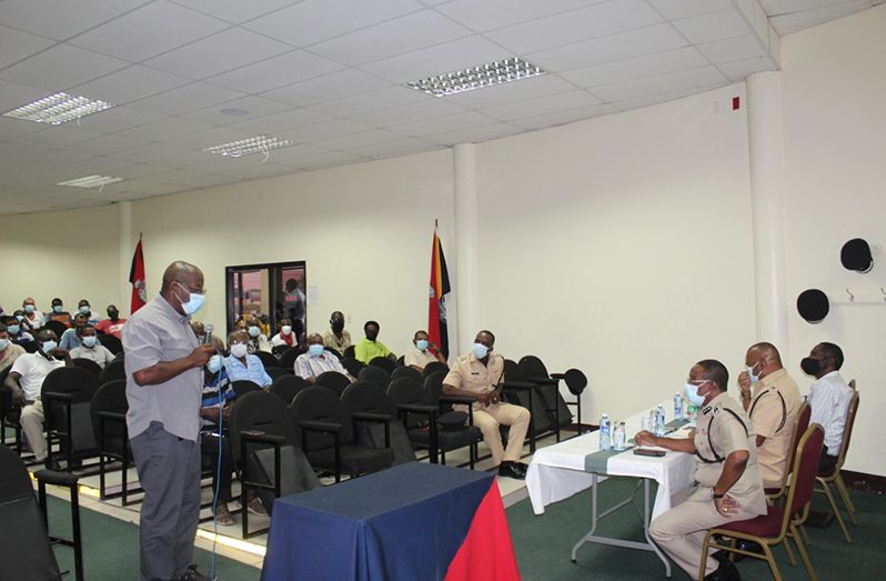 Deputy Commissioner of Police, (ag), Clifton Hicken, seated left at head table, pays keen attention to some of the issues being raised by a concerned driver