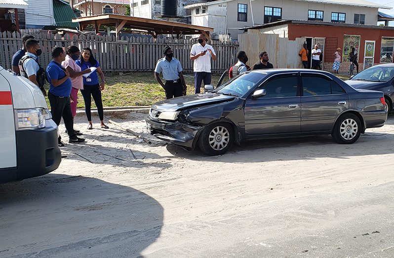 A detective interviews the victim, Romana Spencer (blue shirt), while other cops inspect her vehicle on Hunter Street, West Ruimveldt following the armed robbery