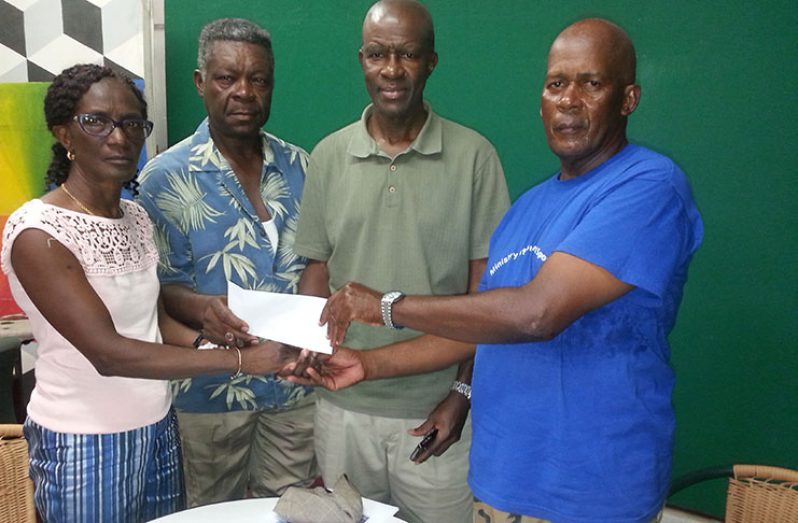 Relatives  of the Felix family is seen handing over the sponsorship cheque to cycling coach, Randolph Roberts.