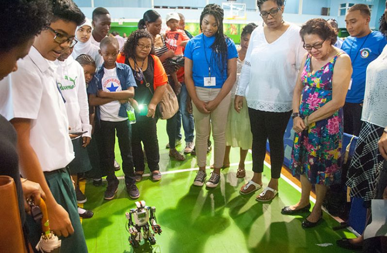 First Lady Sandra Granger (right), STEM Guyana Coordinator Karen Abrams (second right) and others look at the robot’s movements