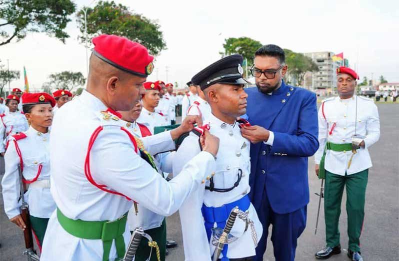 Police Cadet Officer Roger Junior Westmoreland has his new rank pinned onto his shoulders by Commander-in-Chief, His Excellency Dr. Mohamed Irfaan Ali and Chief of Defence Staff, Brigadier Omar Khan,MSS, marking the culmination of two years of rigorous military and academic training