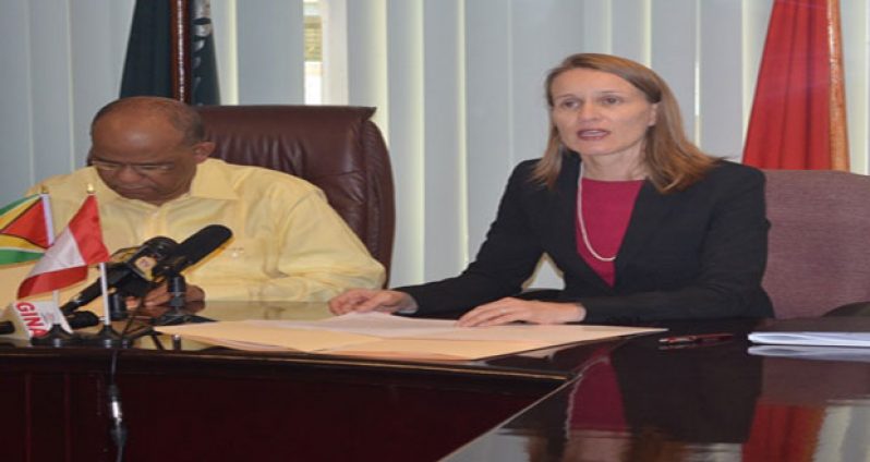 Canadian High Commissioner to Guyana, Ms. Nicole Giles and Home Affairs Minister Clement Rohee during the signing of the MOU for the purchasing of two way radios, and video cameras for the Guyana Police Force and the Customs Anti-Narcotics Unit.