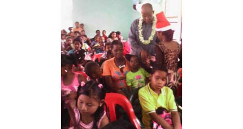 Minister Rohee helping with the distribution of gifts to the children