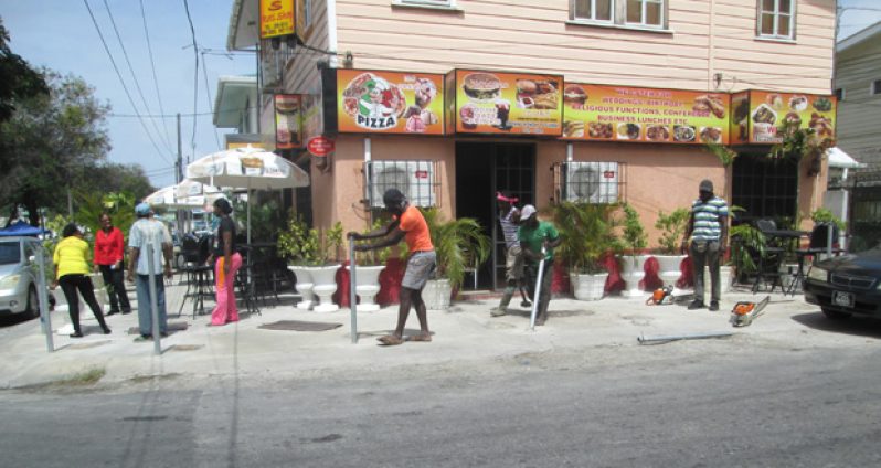 The metal pickets installed at Singh’s Roti Shop being removed by M&CC workers from the pavements in front of the premises