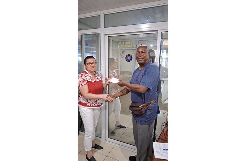 Mrs. Roxanne Hopkinson of Secure Innovation and Concepts Inc., hands over sponsorship to Lennox Braithwaite