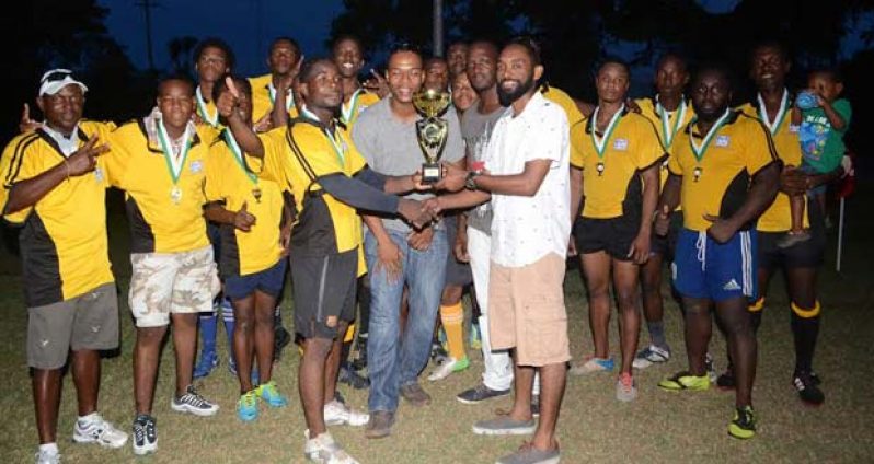 Golden Brook representative Dustani Barrow presents the winner’s trophy to Yamaha Caribs Captain Akeem Fraser, while other sponsors and players look on.
Photo Name: Rugby Presentation