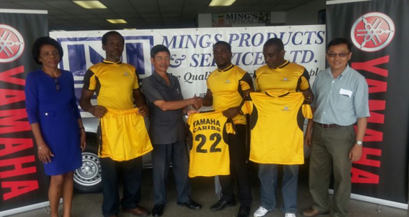 Ming’s Products and Services Ltd proprietor, Stanley Ming, makes the presentation to captain Akeem Fraser while other club officials look on.
