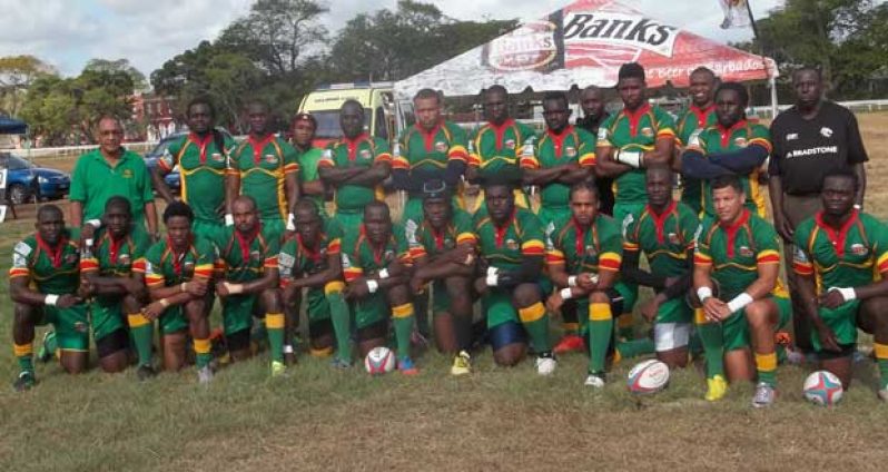 The Guyana NACRA 15s team strike a pose with members of the coaching unit, prior to their game against Barbados at the Garrison Savannah last Saturday, which they won 48-19.