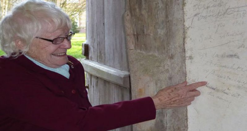 FULL OF EMOTION: Ruth Bettle, 84, with the writing on the barn wall of her late husband Vic Bettle