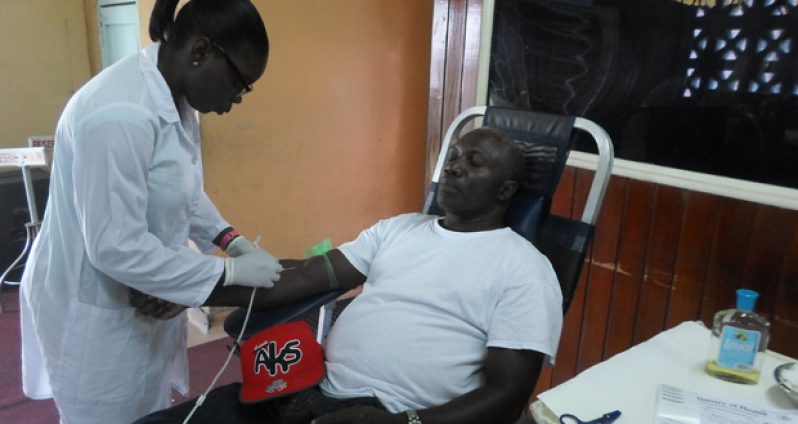 A phlebotomist prepares a donor to give blood