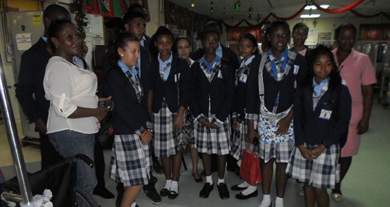 Fifth form students of Achievers Academy visiting the paediatric ward of the GPHC. At left is Mrs. Carol Ann Munro, and at right is Departmental Sister Rhonda Henry