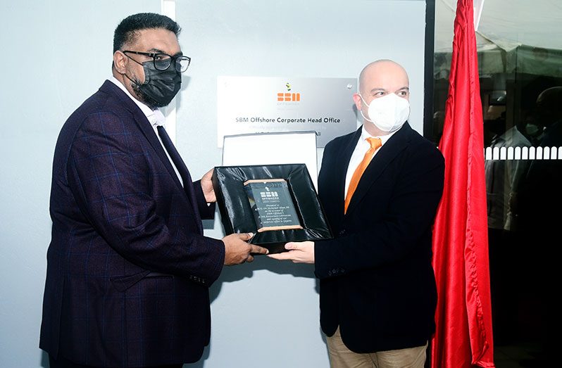 President Dr. Irfaan Ali receiving a token from SBM Offshore General Manager, Francesco Prazzo to mark the company’s fifth anniversary and opening of its corporate office (Adrian Narine Photo)