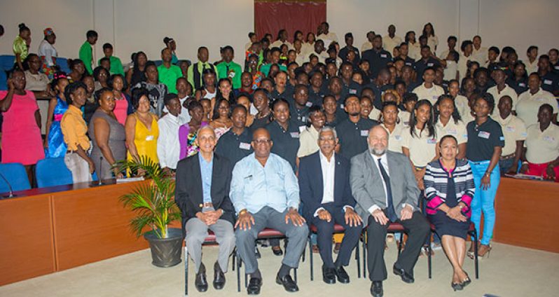 President David Granger (centre)  sits alongside Minister of Communities , Roland Bulkhan (left) , Minister of Finance , Winston Jordan (second left) , US Ambassador to Guyana , Perry Holloway (second right) and Minister within the Ministry of Communities, Dawn Hastings (right) with the graduates at Monday’s event.