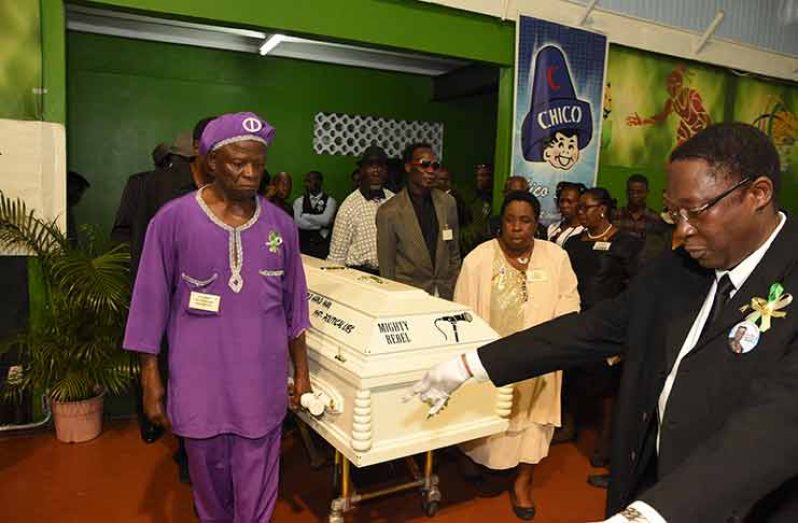 The casket bearing the remains of the “Mighty Rebel” being carried into the Cliff Anderson Sports Hall by fellow calypsonians