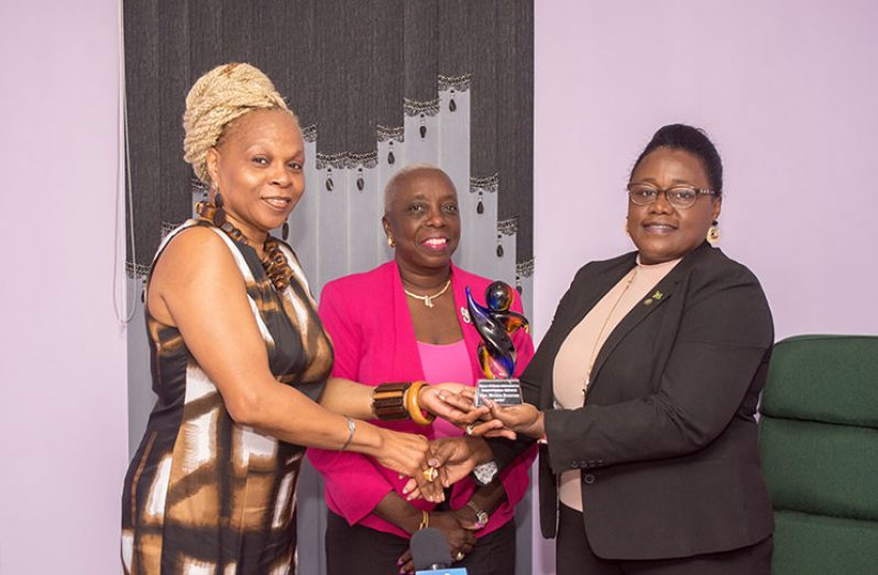 President of the Women of Mission International, Linda Felix-Johnson, presents Minister within the Ministry of Natural Resources, Simona Broomes, with the award for humanitarian service