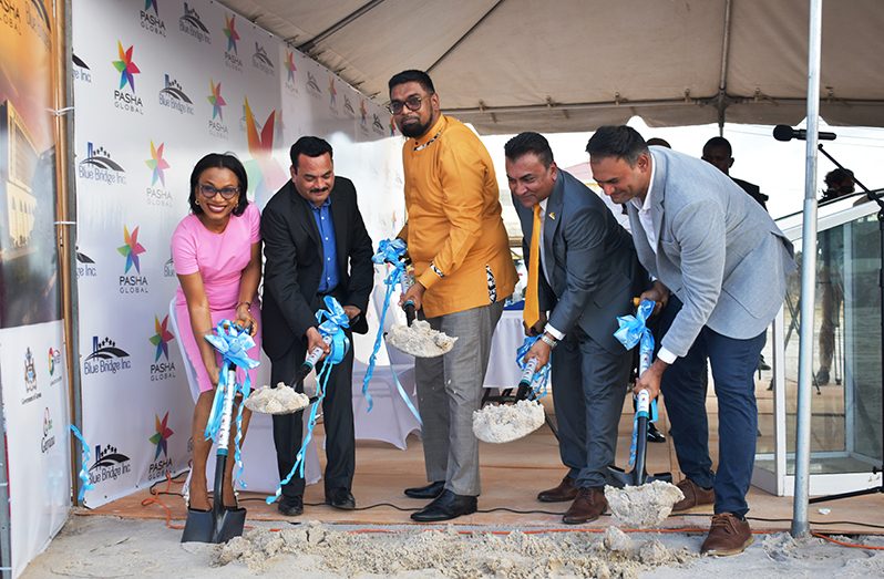 President, Dr. Irfaan Ali (centre); Minster of Tourism, Industry and Commerce, Oneidge Walrond (first from left); Project Director of Blue Bridge Inc. Lalit Sharma (second from left); CEO of the Guyana Office for Investment, Dr. Peter Ramsaroop (second from right); and Assets Director of Blue Bridge Inc., Sanket Balgi (first from right) turn the sod for the construction of the new Pasha Global hotel at Liliendaal (Elvin Croker photo)