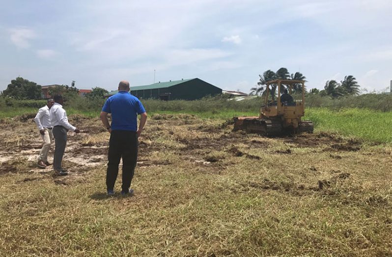 GFF president Wayne Forde is seen (second from left) at the FIFA Forward Programme site, where the land-clearing exercise is being done for Guyana’s first football stadium.