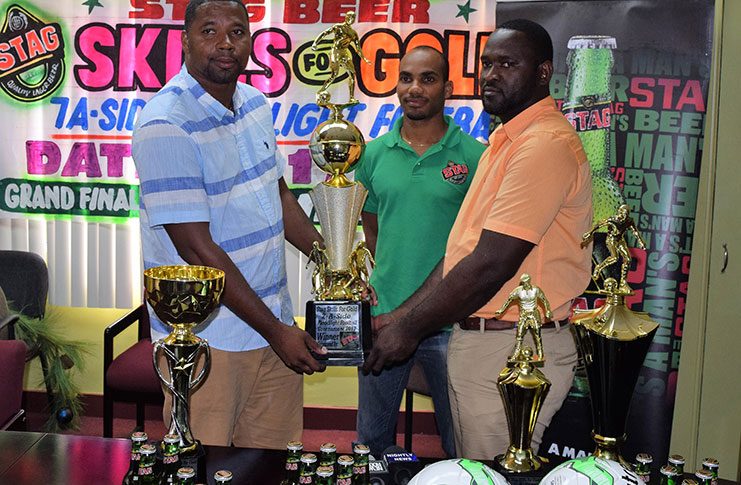 Ansa McAl’s Trade Marketing Assistant for the West Coast Berbice area, Lynton Luke (right) presents promoter Borris Ross with the trophies. Also in photo, STAG Beer Brand representative Lyndon Henry.