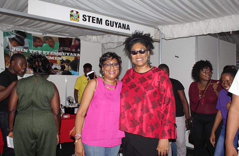Co-Founder of STEM Guyana, Karen Abrams (right) poses with Minister of Public Telecommunication, Cathy Hughes in front of a STEM Guyana exhibit