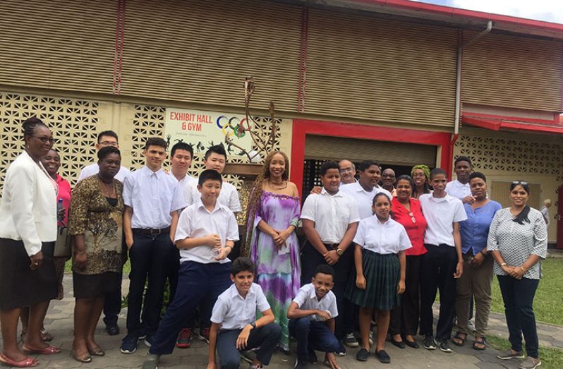 Sonia Noel poses with students during her tour in Suriname