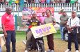 Quinten Sampson sits on the motorcycle he won for being MVP in the open category of the One Guyana Softball competition.